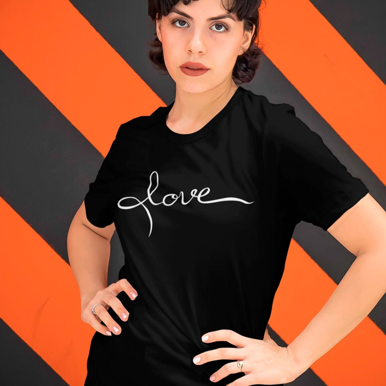 love-black-t-shirt-womens-mockup-featuring-a-woman-standing-in-front-of-a-patterned-wall