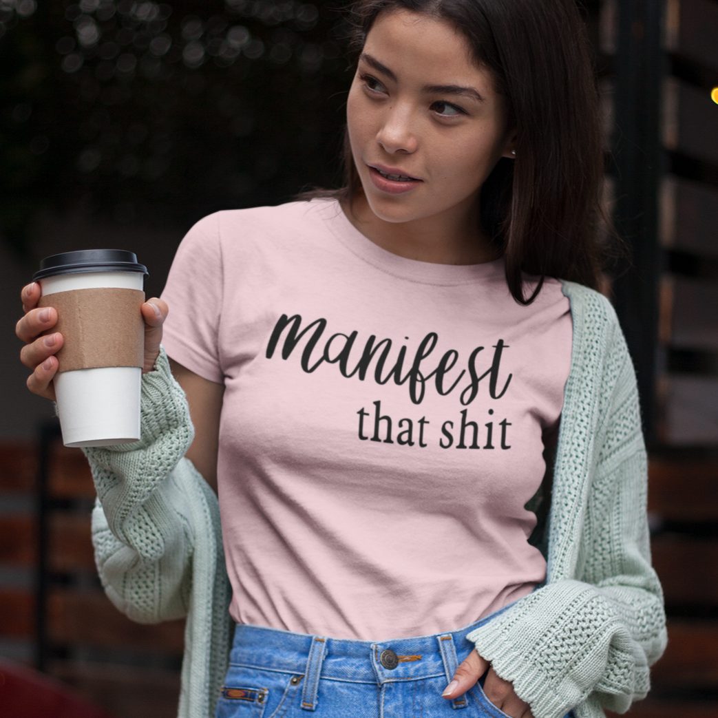 manifest-that-shit-pink-short-sleeve-t-shirt-womens-mockup-of-an-asian-girl-having-a-coffee-outdoors