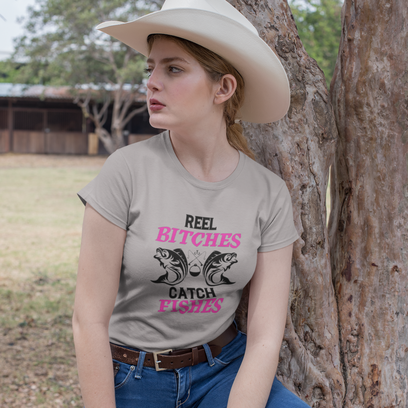 real-bitches-catch-fishes-athletic-heather-t-shirt-fishing-mockup-featuring-a-country-woman-wearing-a-crewneck-t-shirt-outdoors