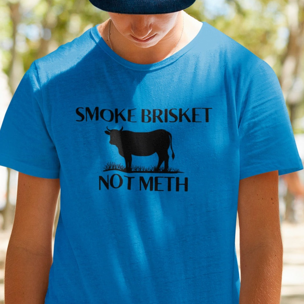 smoke-brisket-not-meth-heather-royal-blue-t-shirt-funny-cow-design-template-of-a-young-man-posing-at-a-park