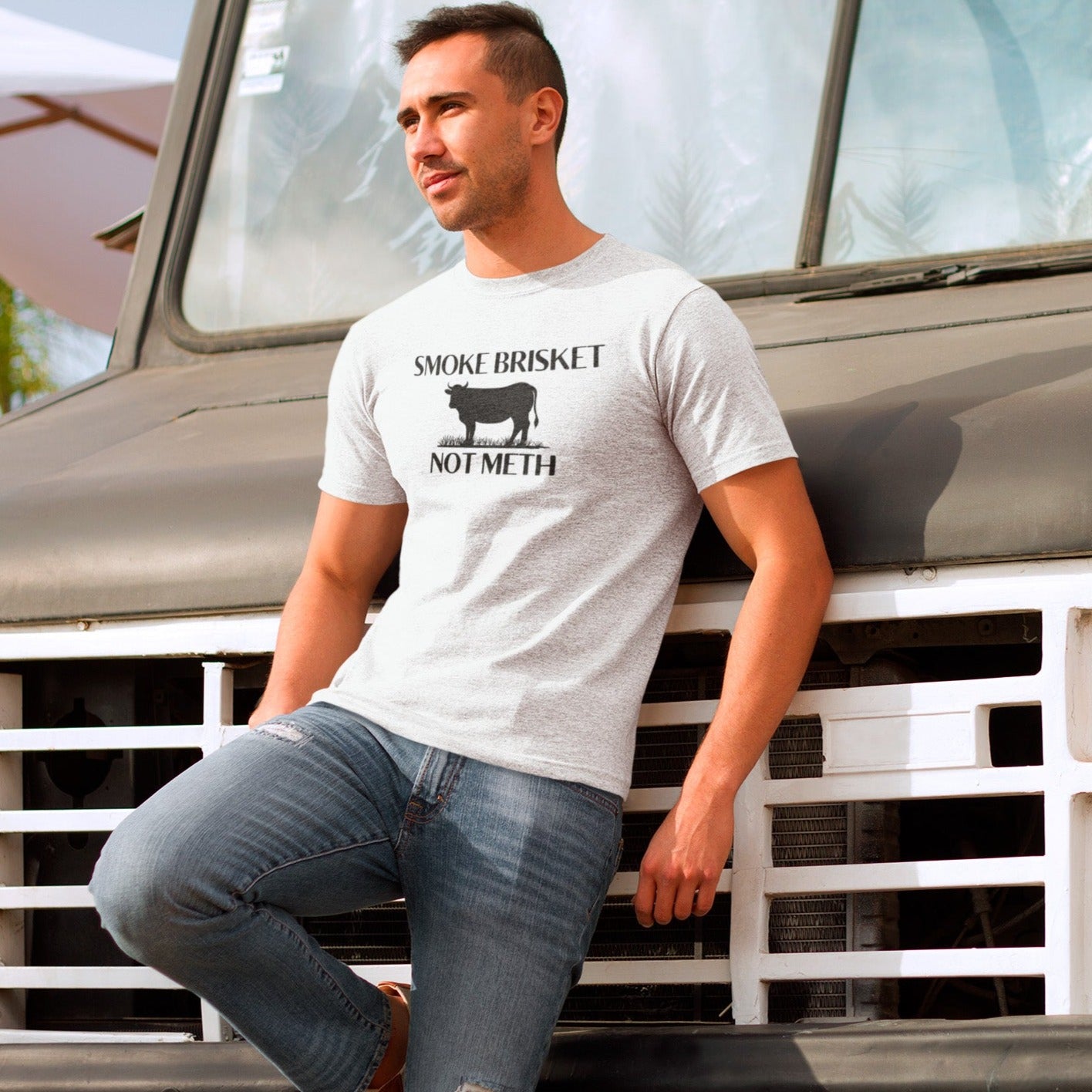 smoke-brisket-not-meth-white-t-shirt-funny-cow-mockup-of-a-young-man-leaning-on-an-old-truck