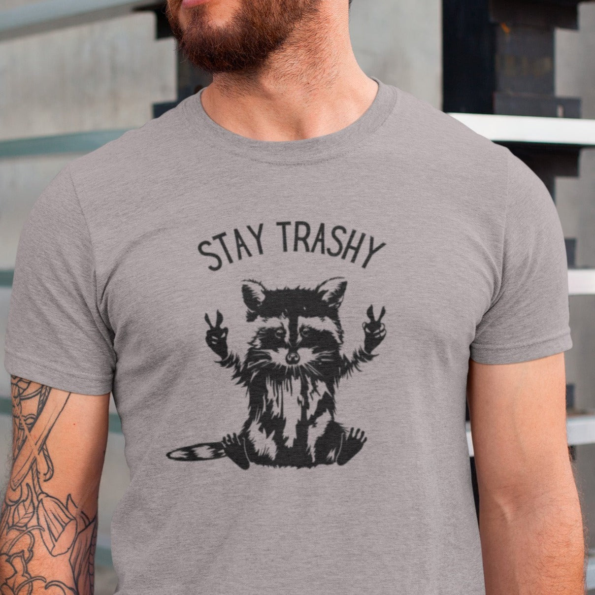 stay-trashy-with-racoon-athletic-heather-t-shirt-unisex-mockup-featuring-a-man-with-tattoos-on-one-arm
