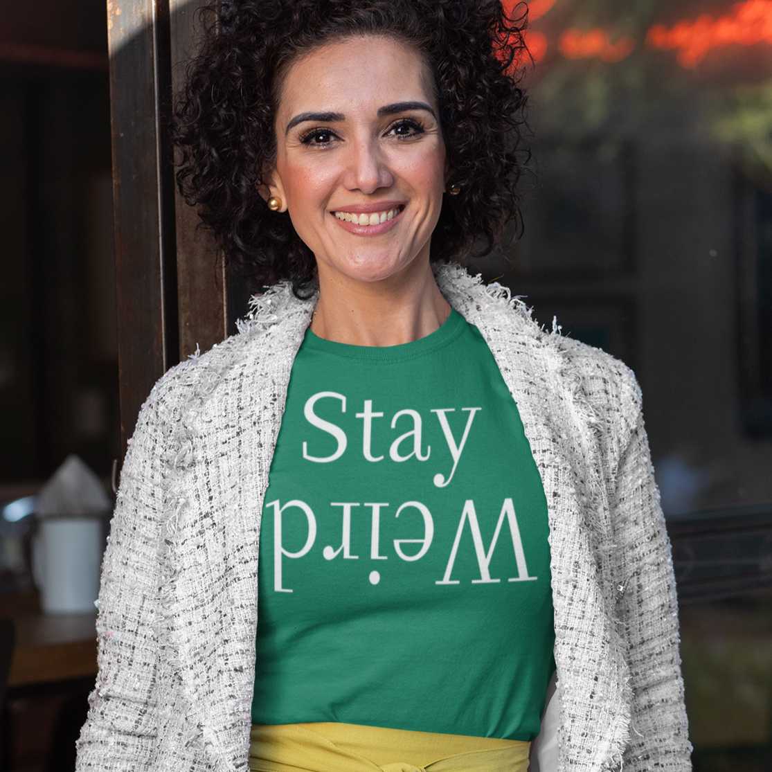 stay-weird-heather-kelly-t-shirt-unisex-mockup-featuring-a-middle-aged-woman-with-curly-hair-by-a-restaurant-window