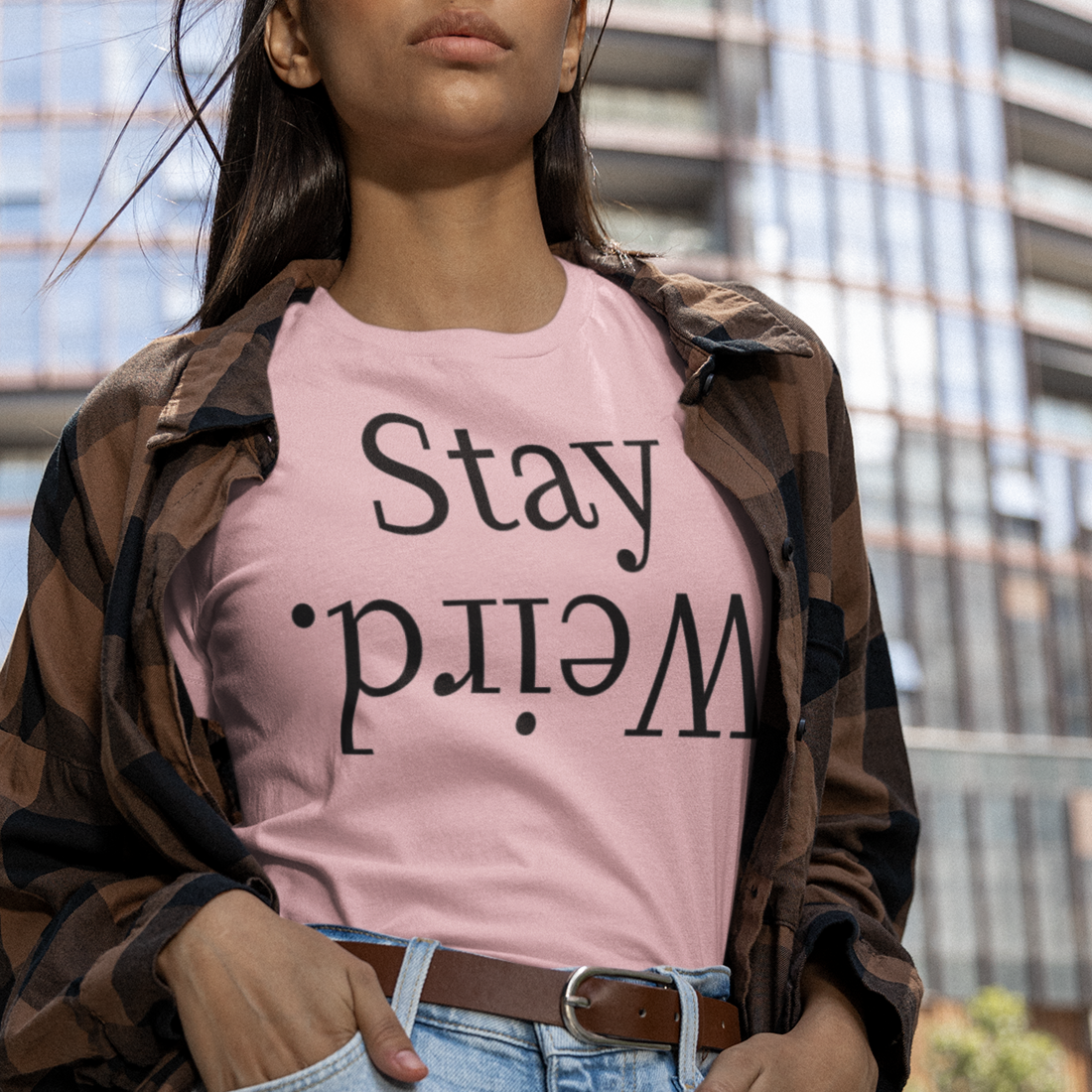 stay-weird-pink-t-shirt-unisex-mockup-of-a-woman-posing-in-a-round-neck-bella-canvas-tee-by-a-building